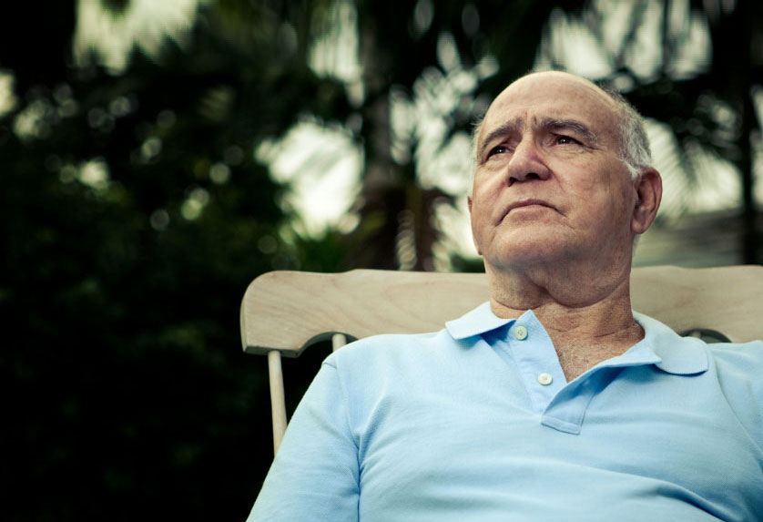 elderly man in blue shirt looking off into the distance